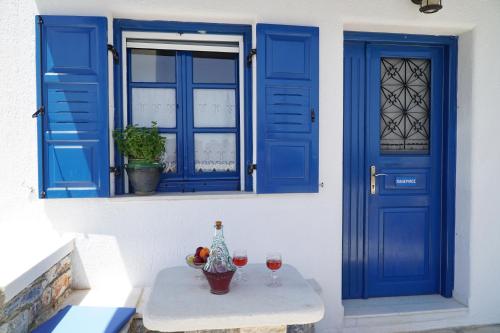 MoutsoúnaMoutsouna Beach II的蓝色的门和一张桌子及酒杯