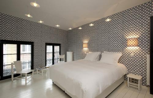 布鲁塞尔La Maison Haute guesthouse的卧室配有白色的床和黑白墙