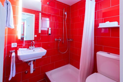 里施Hotel Bauernhof - Self Check-In Hotel的红色的浴室设有水槽和卫生间