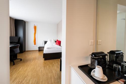 里施Hotel Bauernhof - Self Check-In Hotel的带厨房的房间和配有床的房间