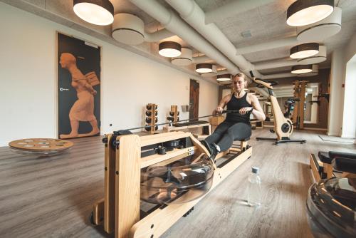 托尔斯港Hotel Brandan的一名在健身房跑步机上锻炼的女子