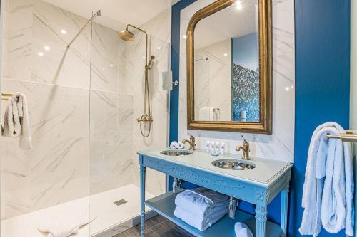勒宝洛瑞莱斯查图士酒店的蓝色和白色的浴室设有水槽和淋浴