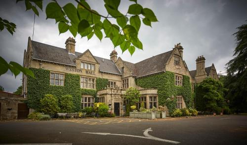 BulkingtonWeston Hall Hotel Sure Hotel Collection by Best Western的街道旁的一座被绿色常春藤覆盖的建筑