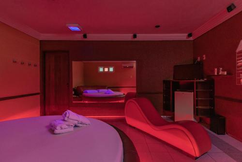 福塔莱萨梦幻汽车旅馆（仅限成人）的红色的房间,里面设有床和椅子