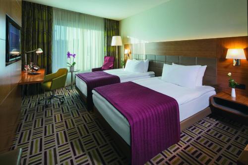 安卡拉莫文皮克安卡拉酒店的酒店客房,配有两张带紫色床单的床