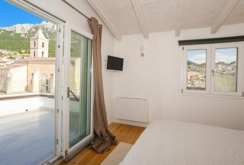 奥列纳Tatta & Nanna Rooms的一间卧室设有一张床和一个大窗户