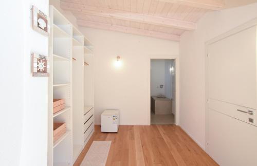 奥列纳Tatta & Nanna Rooms的一间拥有白色墙壁和木地板的客房以及走廊