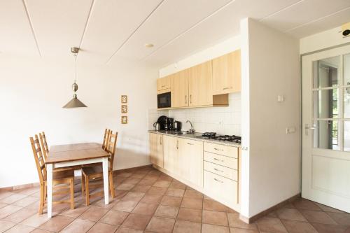 赫鲁斯贝克瓦坎提霍斯特度假屋的厨房配有木桌和桌椅