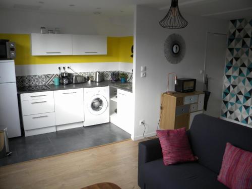 里尔Apartment Lille - Proche métro - Stationnement gratuit的带沙发的客厅和厨房