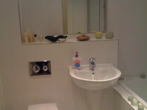希灵登希思罗机场苹果屋宾馆的白色的浴室设有水槽和镜子
