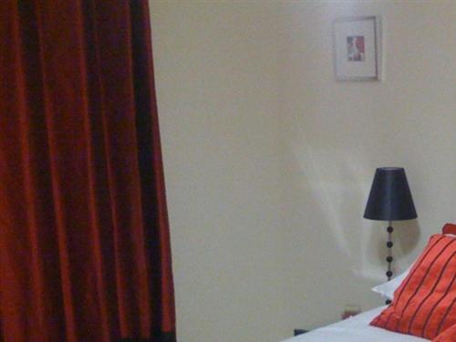 希灵登希思罗机场苹果屋宾馆的一间卧室配有床、灯和窗帘