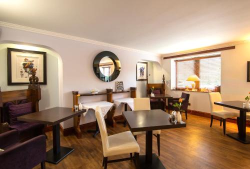 巴拉特奥尔德柯克酒店的餐厅设有桌椅和镜子