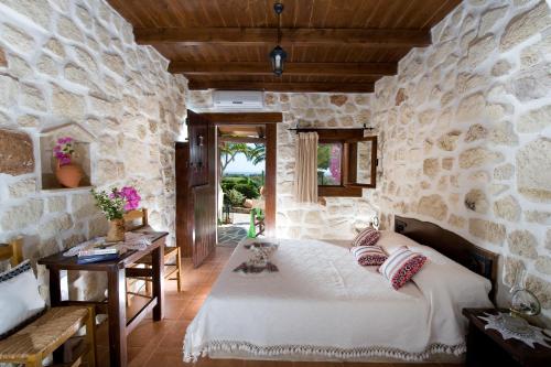 加藤扎克罗斯Yiannis Retreat的卧室配有一张石墙床