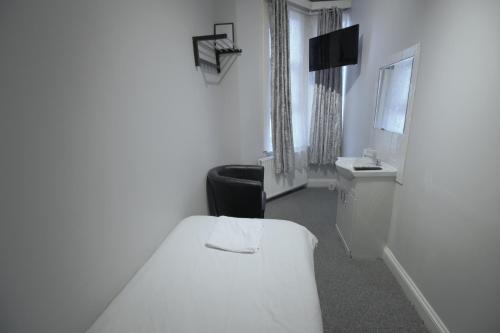 克罗伊登伦敦克罗伊登 - 钟楼酒店的一间白色的小房间,配有床和水槽