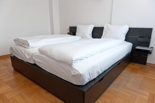 克拉科夫Villa Verona的一张配有白色床单和枕头的大床
