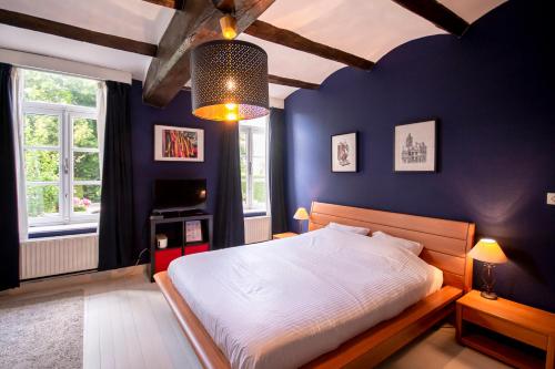 蒙斯金佩蒂特龙旅馆的一间卧室配有一张蓝色墙壁的床