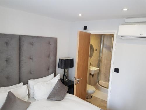 伦敦Luxlogic的一间卧室配有一张床,浴室设有卫生间