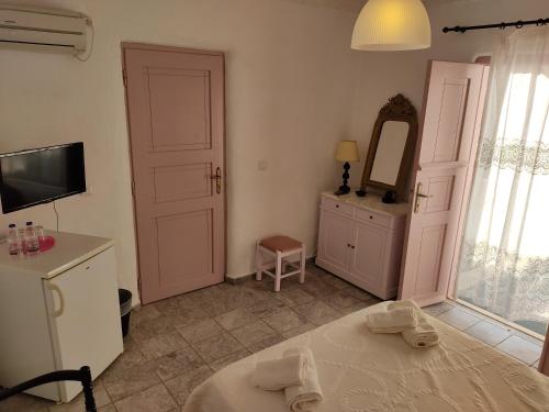 AloproniaPorto Sikinos Hotel的一间卧室配有一张床、镜子和电视