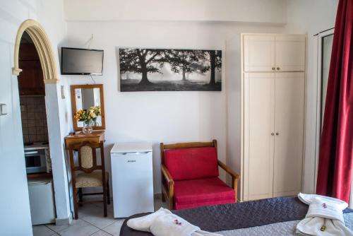 帕拉马Empress Corfu的客厅配有红色椅子和电视