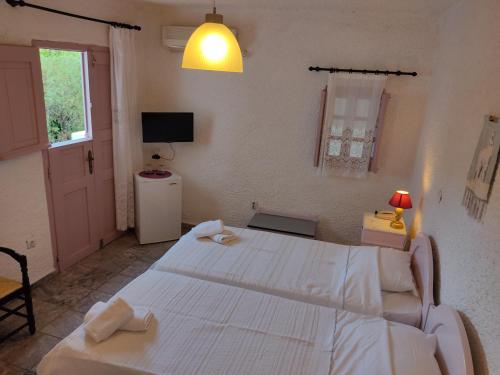 AloproniaPorto Sikinos Hotel的一间卧室配有两张白色的床和电视