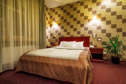 哈尔科夫维多利亚酒店的酒店客房,配有床和植物