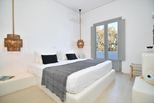 佩里萨艾吉爱斯酒店的一间白色卧室,配有两张床和窗户