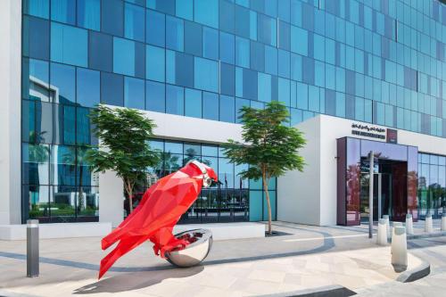 迪拜Radisson RED Dubai Silicon Oasis的一座大楼前的一座红色超级英雄雕像