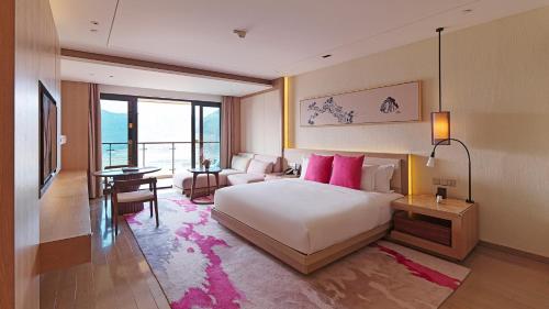 象山宁波象山海景皇冠假日酒店的一间卧室配有一张床、一张沙发和一张桌子