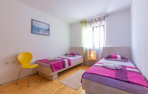 奥米什Apartments Ivka的一间卧室配有两张床和一张黄色椅子