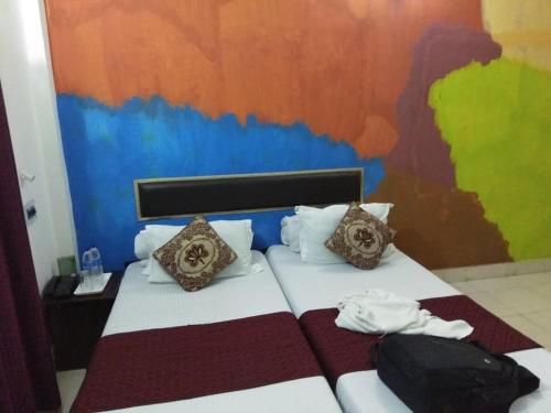 Mādāri HātMystic resort amidst Tea Garden的一间卧室配有一张带彩色墙壁的床