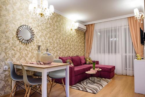 阳光海滩Sweet Homes 6 Apartments的客厅配有紫色沙发和桌子