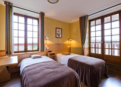 Chambon-sur-Dolore拉格莱德酒店的酒店客房带两张床和两个窗户