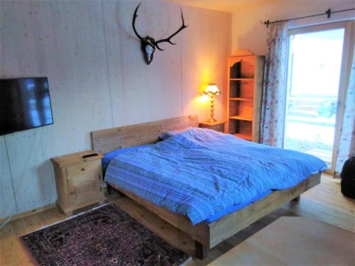 隆高地区圣玛格丽滕Country Appartement Lungau的一间卧室配有一张带蓝色棉被的床和窗户。