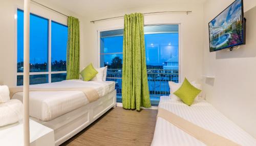 洛坤府查达@洛酒店的一间卧室设有两张床和大窗户