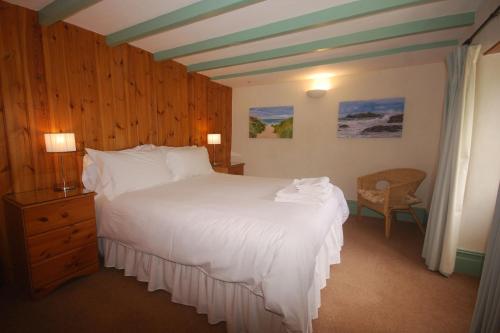 纽基Granary at Trewerry Cottages - Away from it all, close to everywhere的卧室配有一张白色大床和一把椅子