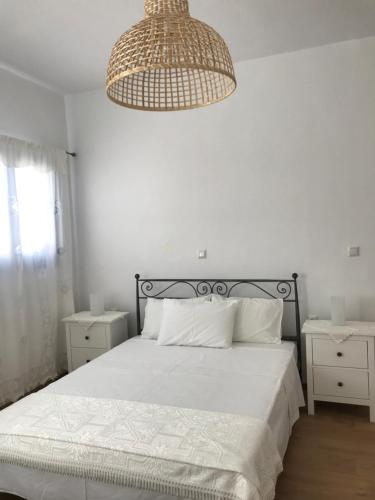 佐努萨岛Vegera Apartment 'Sofrano', Stavros Donoussa的白色卧室配有一张床和一个吊灯