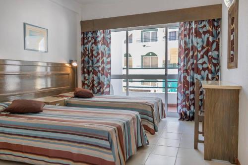 蒙蒂戈杜卡莱玛雅尔丁大道公寓酒店的酒店客房设有两张床和窗户。