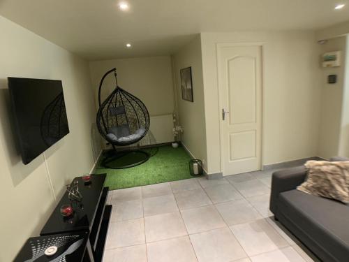 古桑维尔Appartement cosy proche Roissy CDG Astérix DisneyLand Paris的客厅配有沙发和秋千