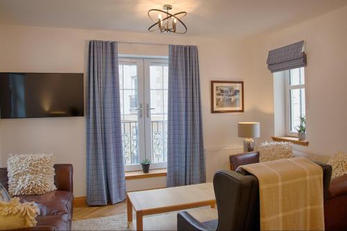 多诺赫Royal Golf Apartments的客厅配有蓝色窗帘和沙发