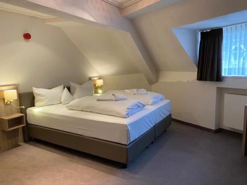 蒙绍霍岑酒店-餐厅-咖啡厅-酒吧的一间卧室配有一张带白色床单的床和一扇窗户。