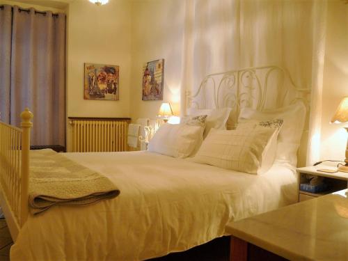 蒙帕齐耶切斯埃戴尔宾馆的卧室配有一张带白色床单和枕头的大床。