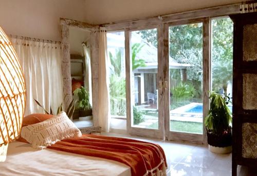 乌鲁瓦图巴厘岛三泰别墅的一间卧室设有一张床和一个大窗户