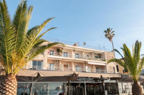 纳夫普利翁Di fronte alla fortezza的前面有棕榈树的酒店