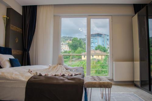 特拉布宗ELEGANT BLUE SUİTES的一间卧室设有一张床和一个大窗户
