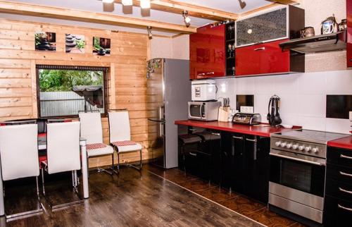 米日吉里亚Файна Хижа的厨房配有红色橱柜和桌椅