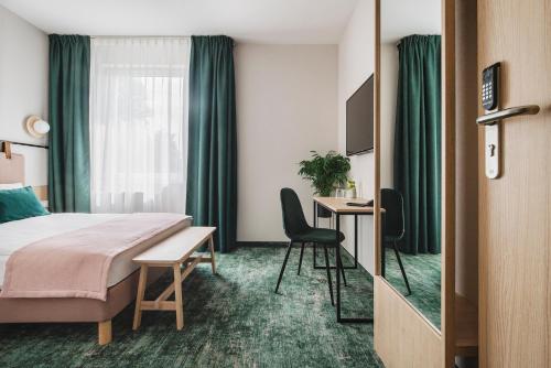 格但斯克雷比赫瓦Hi Hotel Gdansk Airport的配有一张床和一张书桌的酒店客房