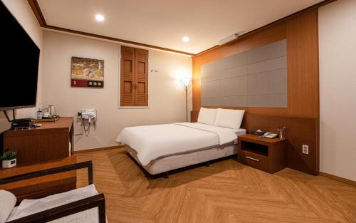 仁川市仁川爱特尔酒店的一间卧室配有一张床、一张书桌和一台电视