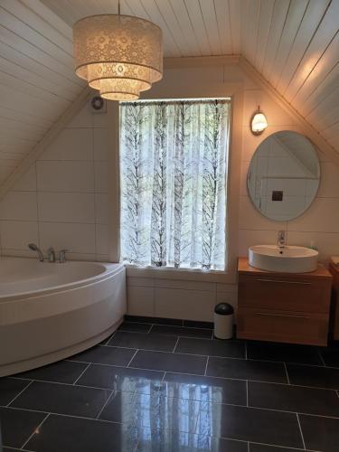 LauvstadIrenegarden - Fjord view holiday home的带浴缸、水槽和窗户的浴室
