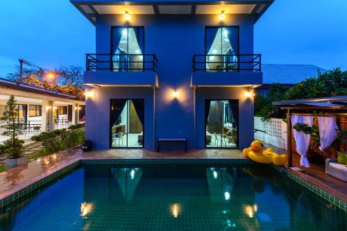 班武里府Aownoi Bay Resort的房屋前有游泳池的房子