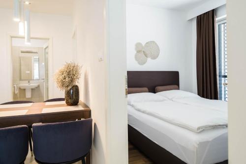 凯斯特海伊Apartman Balaton privát stranddal的一间卧室配有一张床和一张桌子及椅子